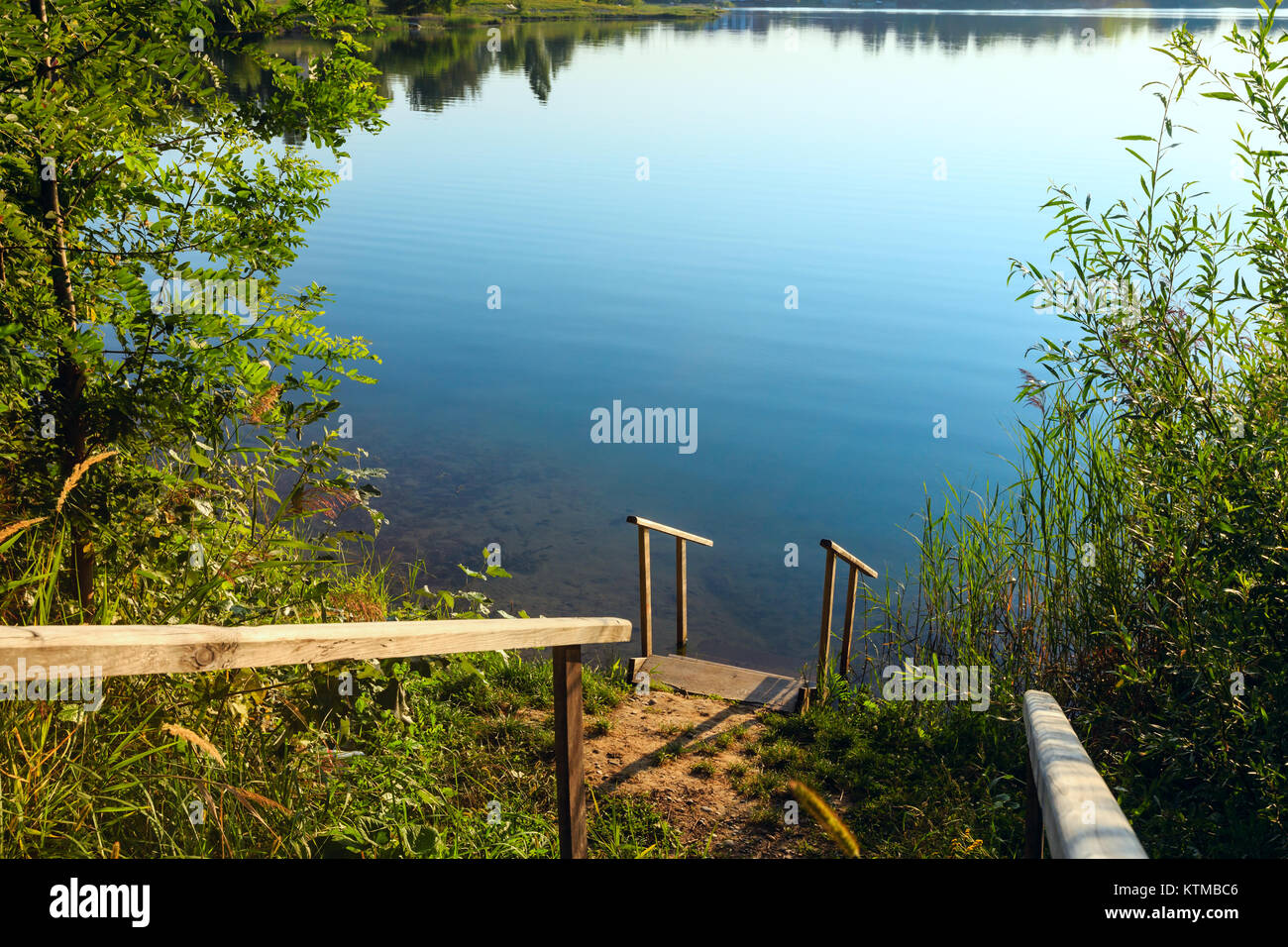 Escaliers de bois jusqu'à la pittoresque rive du lac matin d'été. Concept de la vie de campagne tranquille, éco-tourisme, le camping, la pêche. Banque D'Images