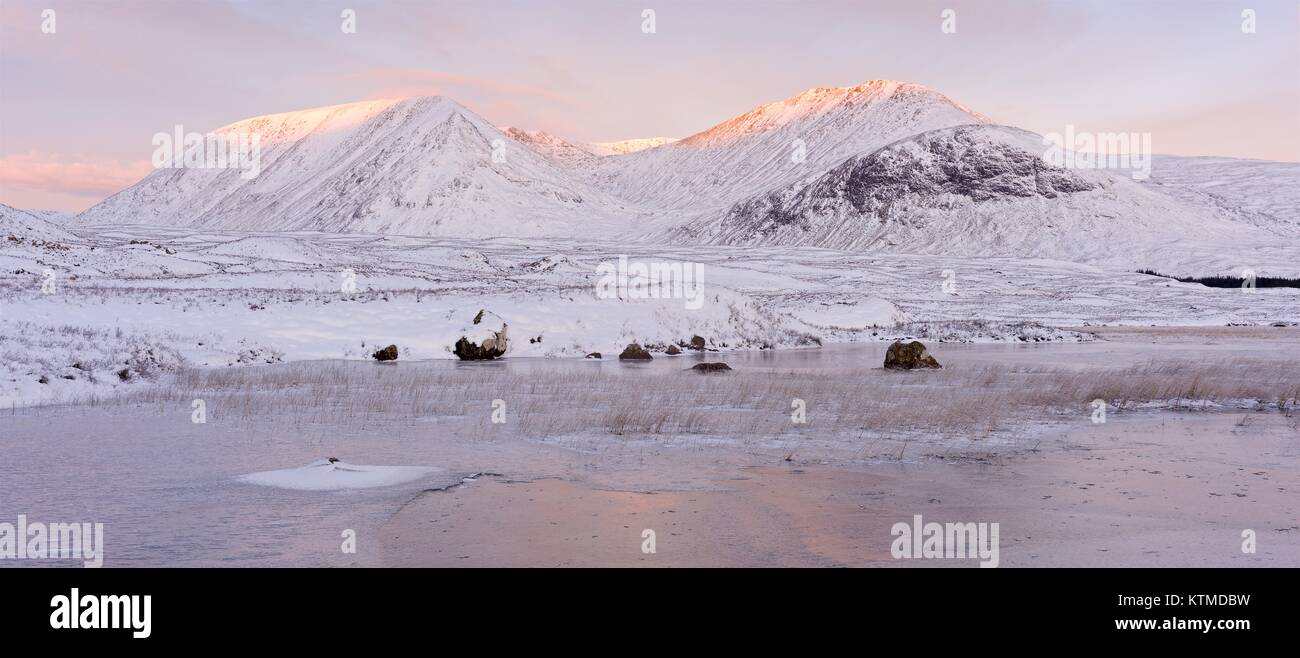 Une image couleur de la monture noire sur un hivers coloré le lever du soleil. La photo est prise à partir d'une petite sur le lochan congelé West Highland way route Banque D'Images