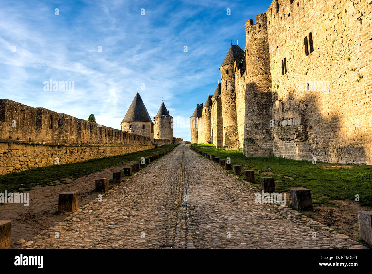 La rue antique entre les murs d'une fortification médiévale sous un ciel bleu nuageux Banque D'Images