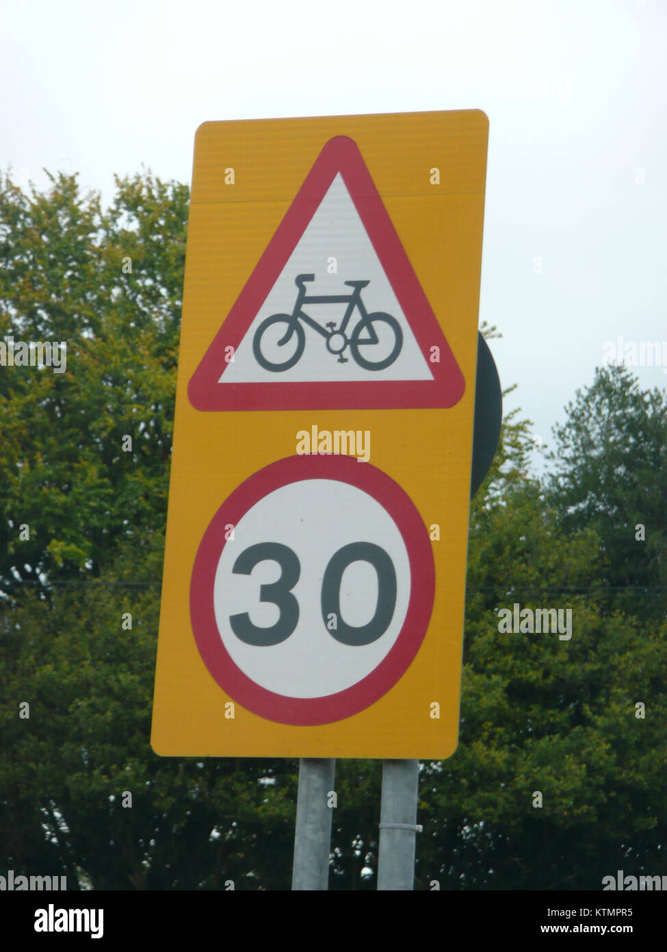 Cette image représente un panneau de signalisation à Liphook, dans le Hampshire, avertissant d'une route cyclable combinée et d'une limite de vitesse de 30 km/h. Le panneau est conçu pour assurer la sécurité des cyclistes et des conducteurs en les avertissant des vitesses réduites et de la présence de cyclistes partageant la route. Banque D'Images