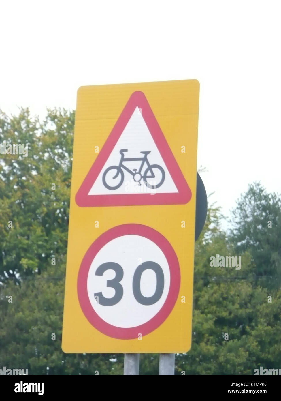 Un avertissement combiné d'itinéraire cyclable et un panneau de limite de vitesse de 30 mph est situé à Liphook, Hampshire. Ce panneau indique à la fois la présence d'une piste cyclable et une limitation de vitesse pour les véhicules, favorisant la sécurité des cyclistes et des conducteurs. Banque D'Images