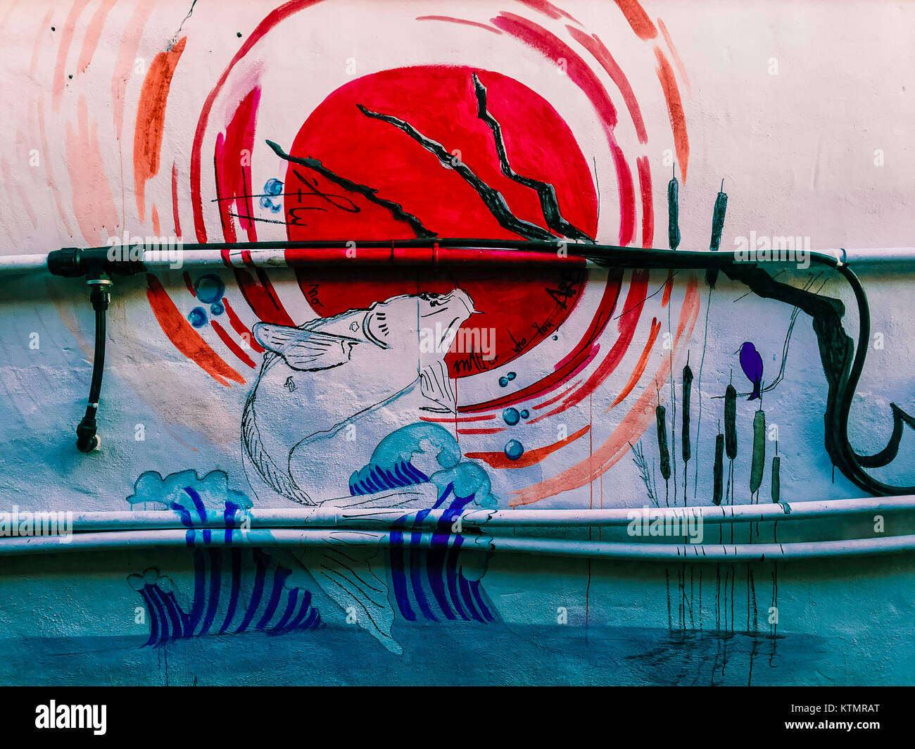 Dessin. Dessin d'un artiste inconnu sur le mur. Poisson rouge dans la mer au coucher du soleil. Banque D'Images