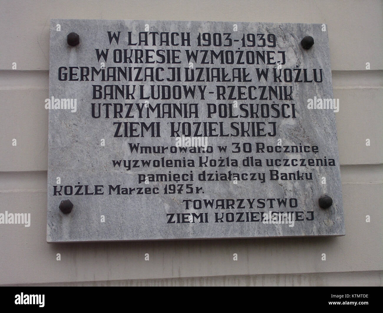 Cette image présente une plaque commémorative dédiée à la Banque Ludowy Kozle, commémorant son importance historique et son rôle dans le développement économique et culturel de la regionâ. Banque D'Images