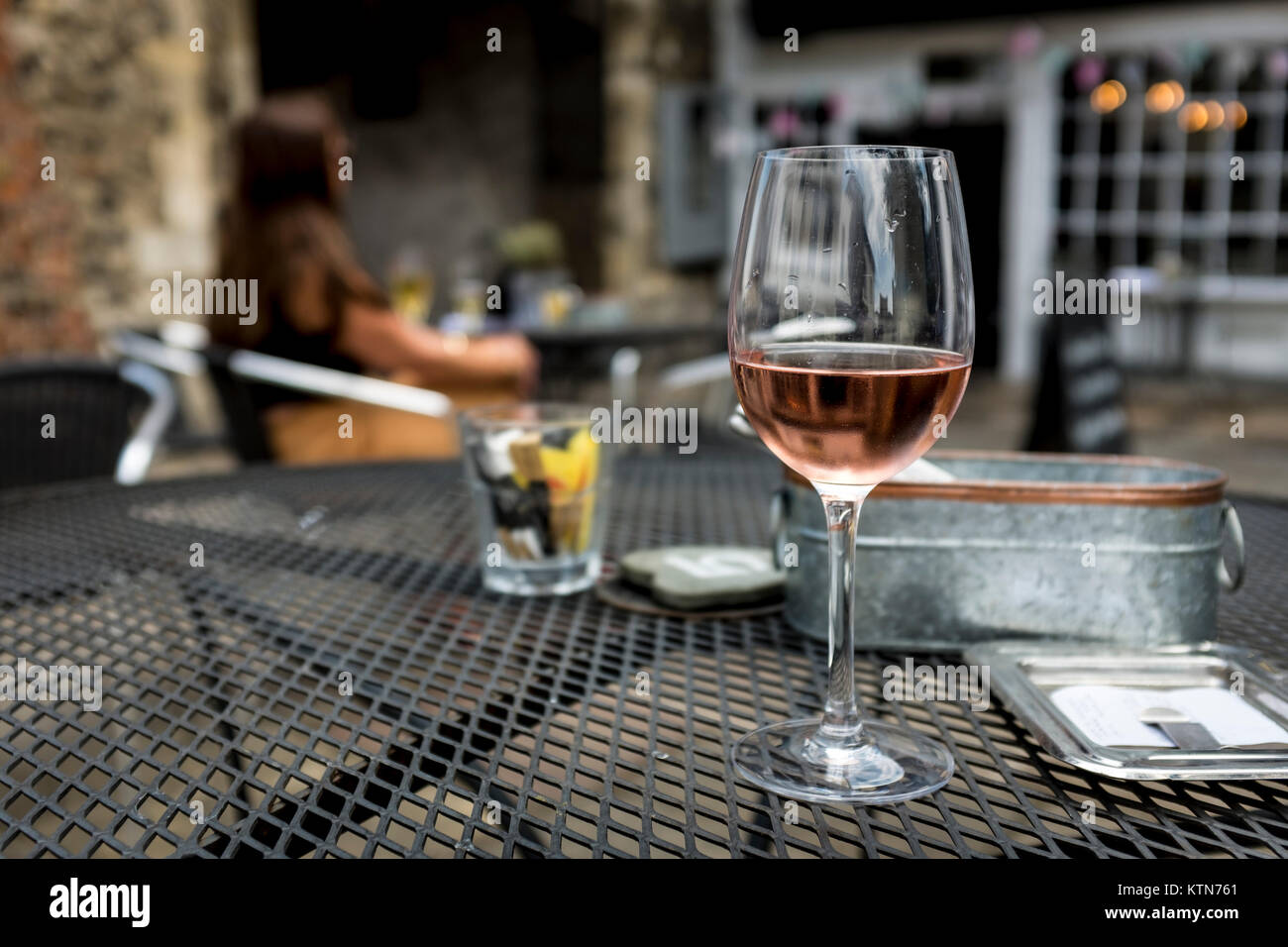 Un verre de vin rose rose sur la table de la chaussée Cafe, UK Banque D'Images