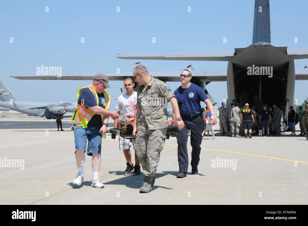 Le sergent de l'US Air Force. Paul Dempsey un compagnon de protection incendie avec le 105e Escadron de génie civil, de la Garde Nationale de New York et locaux le personnel médical d'urgence le transport d'un patient simulé à partir d'un 109e Airlift Wing C-130 Hercules au cours de l'exercice catastrophe nationale Medical System Golden Eagle III à Stewart Air National Guard Base, N.Y., 1 juin 2013 . La SNAC met à l'épreuve la capacité des fournisseurs de services médicaux locaux à participer à la circulation des patients de régions touchées par une catastrophe à d'autres endroits pour recevoir des soins médicaux. (U.S. Air National Guard photo de Tech. Le Sgt. Mi Banque D'Images