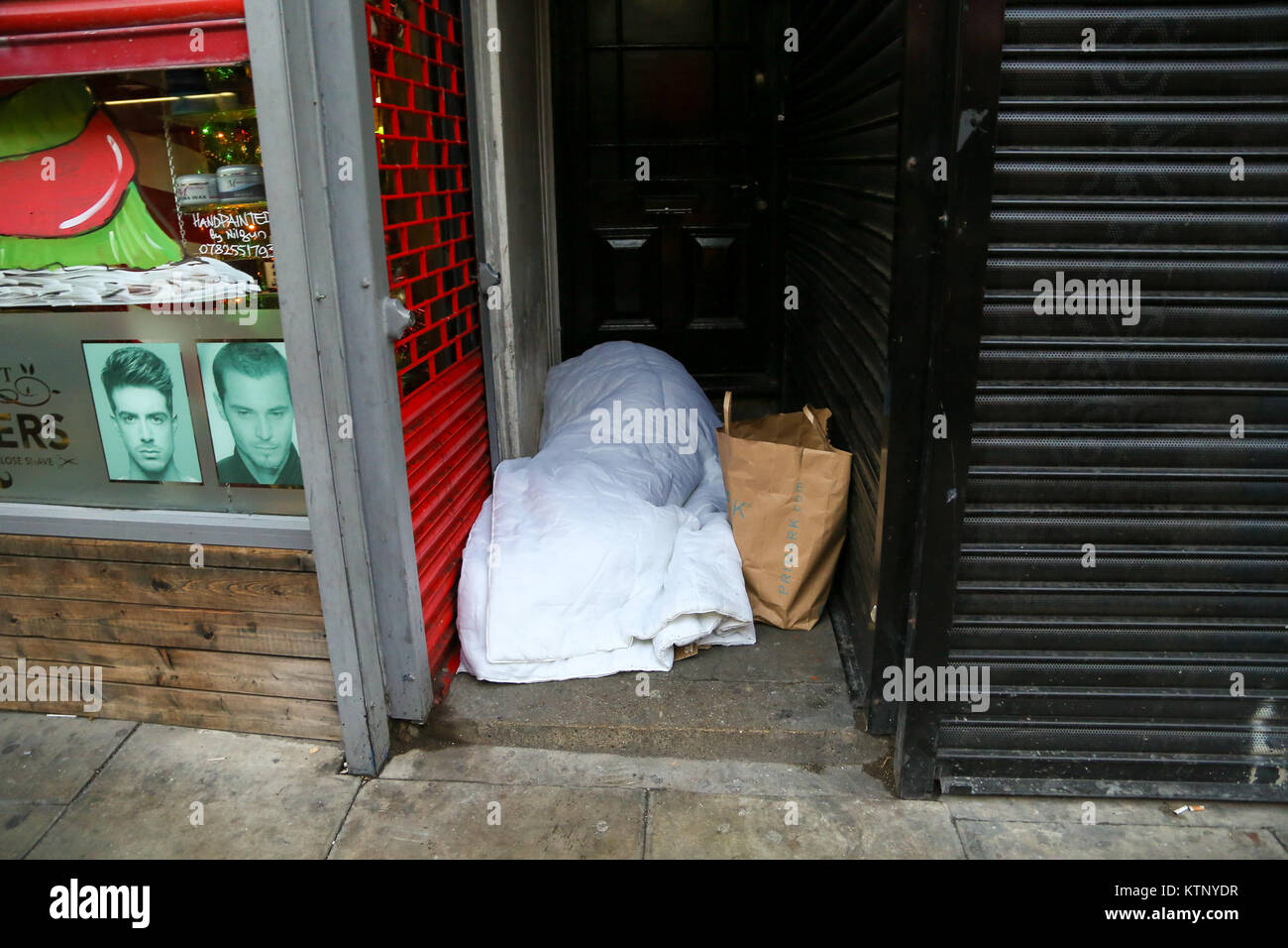 Le nord de Londres, Royaume-Uni. 28 Dec, 2017. Une personne dormant sur une porte très étroite avec l'écart entre les boutiques dans le nord de Londres après une nuit très froide. Selon le Comité des comptes publics plus de 9 000 personnes sont sans-abri dans les rues. Credit : Dinendra Haria/Alamy Live News Banque D'Images
