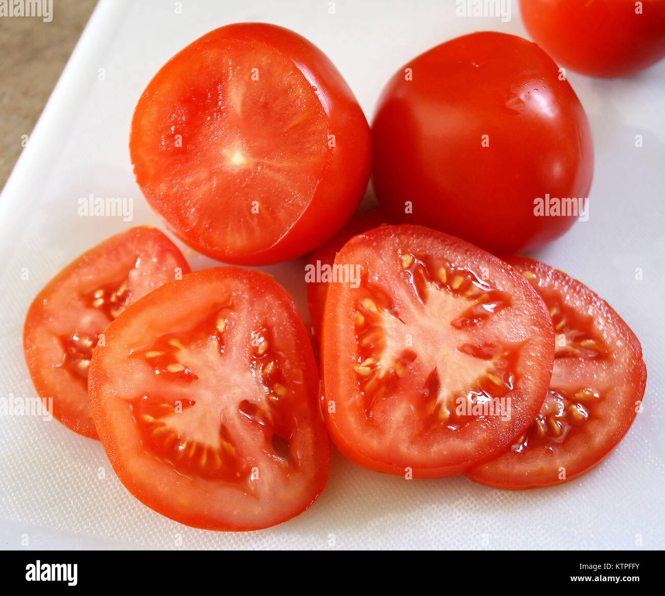 Freshly sliced tomates biologiques on cutting board Banque D'Images