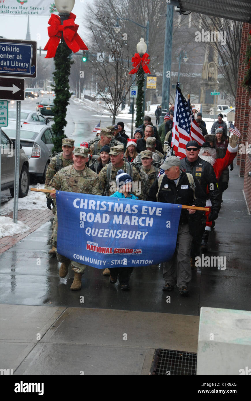 New York les soldats de la Garde nationale de l'Armée du Centre de préparation à Queensbury inscrivez-vous des dizaines de membres des familles des militaires et des centaines d'amis et les résidents de la collectivité pour la 13e édition de la nuit de Noël roadmarch à Glens Falls, New York le 24 décembre 2016. Les près de 4 mile road mars est organisé par le sergent à la retraite. 1re classe Art Coon, un ancien New York Army National Guard recruteur. Se joindre à Coon dans l'exemple de l'roadmarch est New York le sergent de la Garde nationale de l'armée. 1re classe Adam coiffure qui s'est enrôlé en 2003 et Coon sert maintenant de la même communauté et des dix-année-vieux fils Matthieu. L'roadmarch annuel Banque D'Images