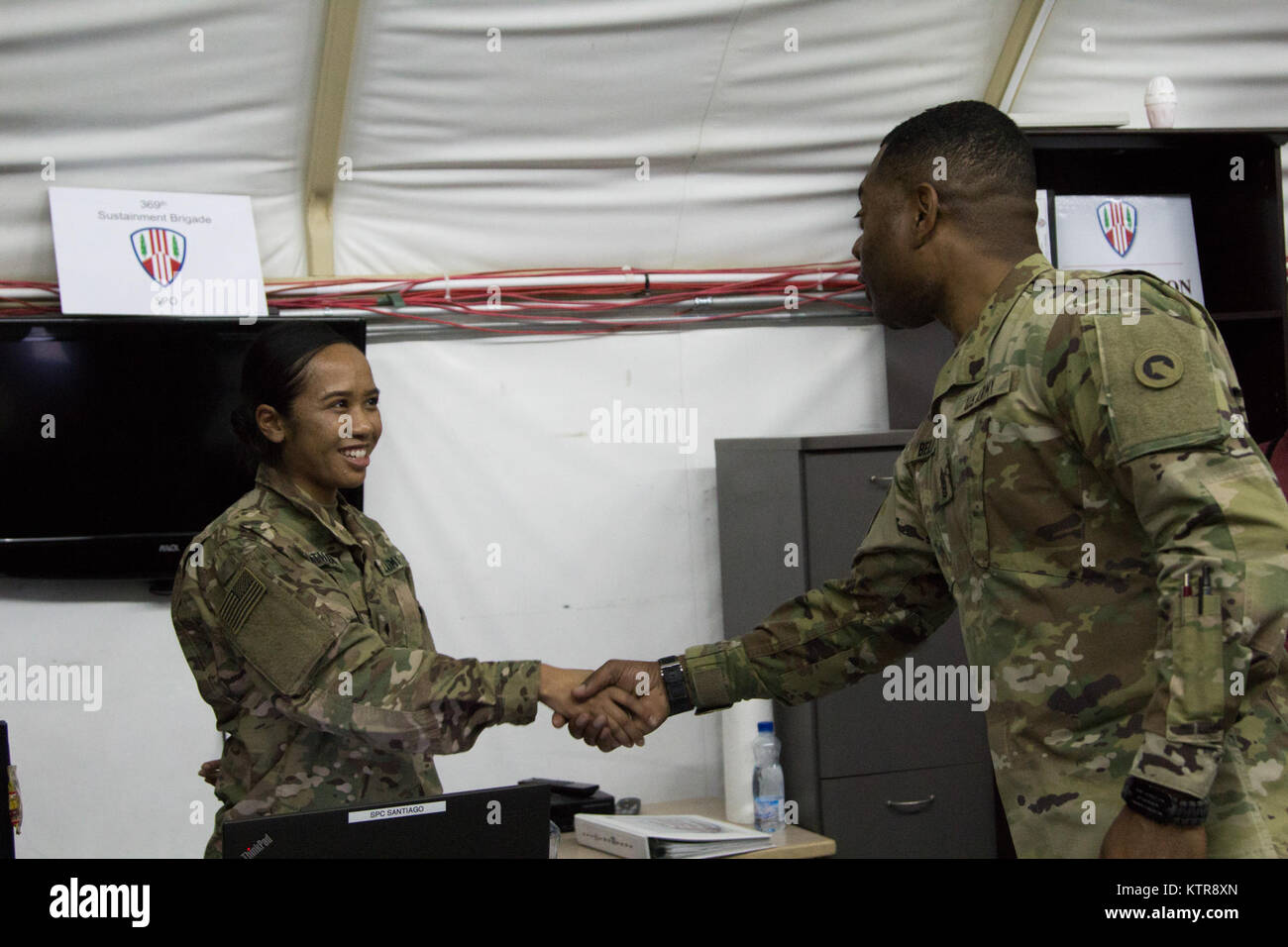 Le Commandement de l'armée américaine le Sgt. Le major Edward Bell, Théâtre 1ère commande soutien hauts enrôlés Advisor, serre la main avec la CPS. Marisa Santiago, 369e Brigade, de soutien au Camp Arifjan, au Koweït, le 29 décembre 2016. Le Sgt commande. Le Major Bell a visité la 369e Brigade de soutien pour rencontrer les soldats de l'unité. (U.S. Photo de l'armée par la CPS. Brixhina Hirsch) Banque D'Images