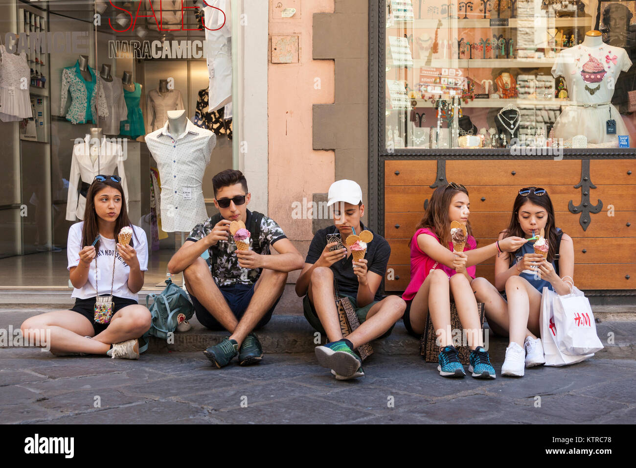 Groupe d'adolescents la consommation de crème glacée à Florence, Italie Banque D'Images