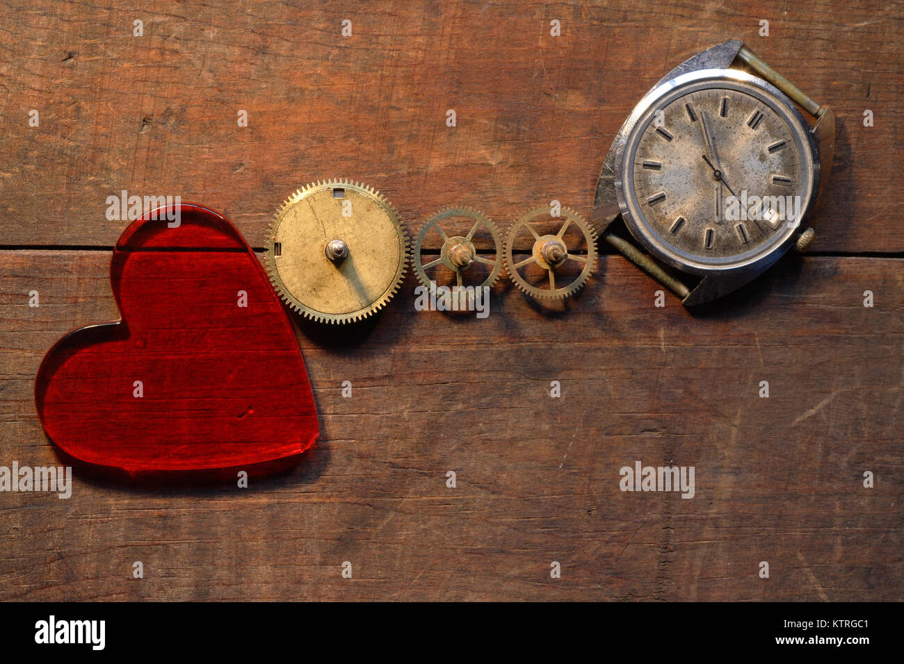 Coeur en verre rouge près de pignons et old watch sur fond de bois Banque D'Images