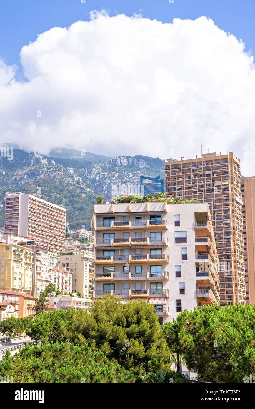 Belle vue sur la lumière du jour à hauteur des bâtiments de la ville, arbres verts et des grandes montagnes. Ciel bleu avec quelques nuages sur l'arrière-plan. Monaco, France Banque D'Images