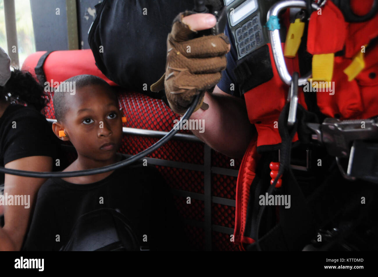 Un enfant regarde le s.. Ryan R. Dush, un pararescuemen avec le 103e Escadron de sauvetage Sauvetage de la 106e escadre affectée à la Garde nationale aérienne de New York, tout en volant dans un HH-60 Pave Hawk hélicoptère au-dessus de la région de Houston, le 30 août 2017. L'enfant a été abandonné en toute sécurité hors de la Montagne Centre à Beaumont, au Texas. (U.S. Photo de la Garde nationale aérienne d'un membre de la 1re classe Daniel H. Farrell) Banque D'Images