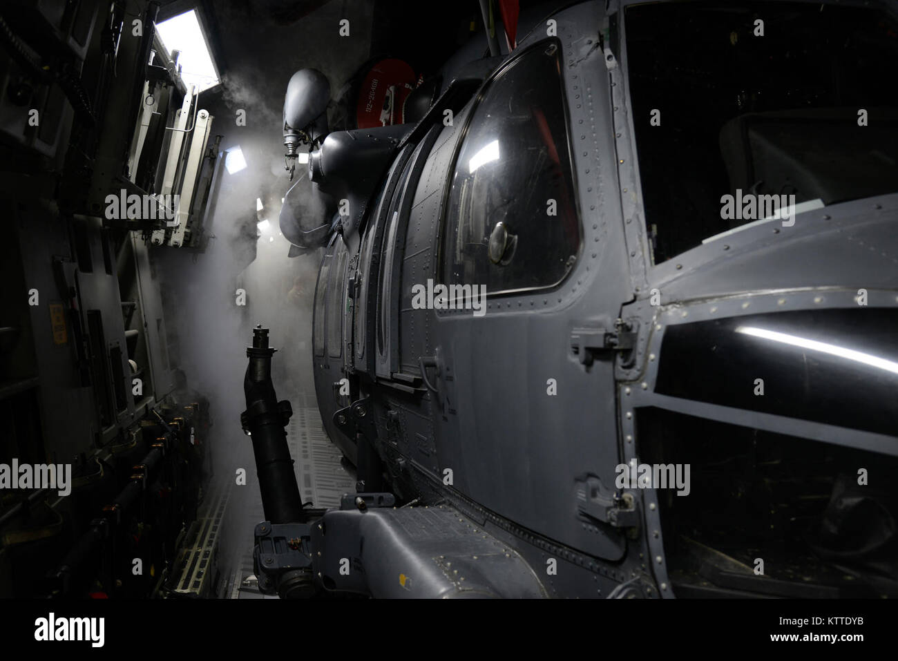 L'air froid de l'intérieur d'un C-17 Globemaster III, affecté à la 105e Airlift Wing, tourne à la brume autour d'un HH-60 Pave Hawk helicopter car elle répond à l'air extérieur chaud et humide à la base de la Garde nationale aérienne Muniz, San Juan, Puerto Rico 7 septembre 2017. Le 106e transportés aviateurs et leur équipement pour les Caraïbes afin qu'ils puissent mener leur mission de sauvetage à sauver des vies. (U.S. Photo de l'Armée de l'air par le sergent. Julio A. Olivencia Jr.) Banque D'Images