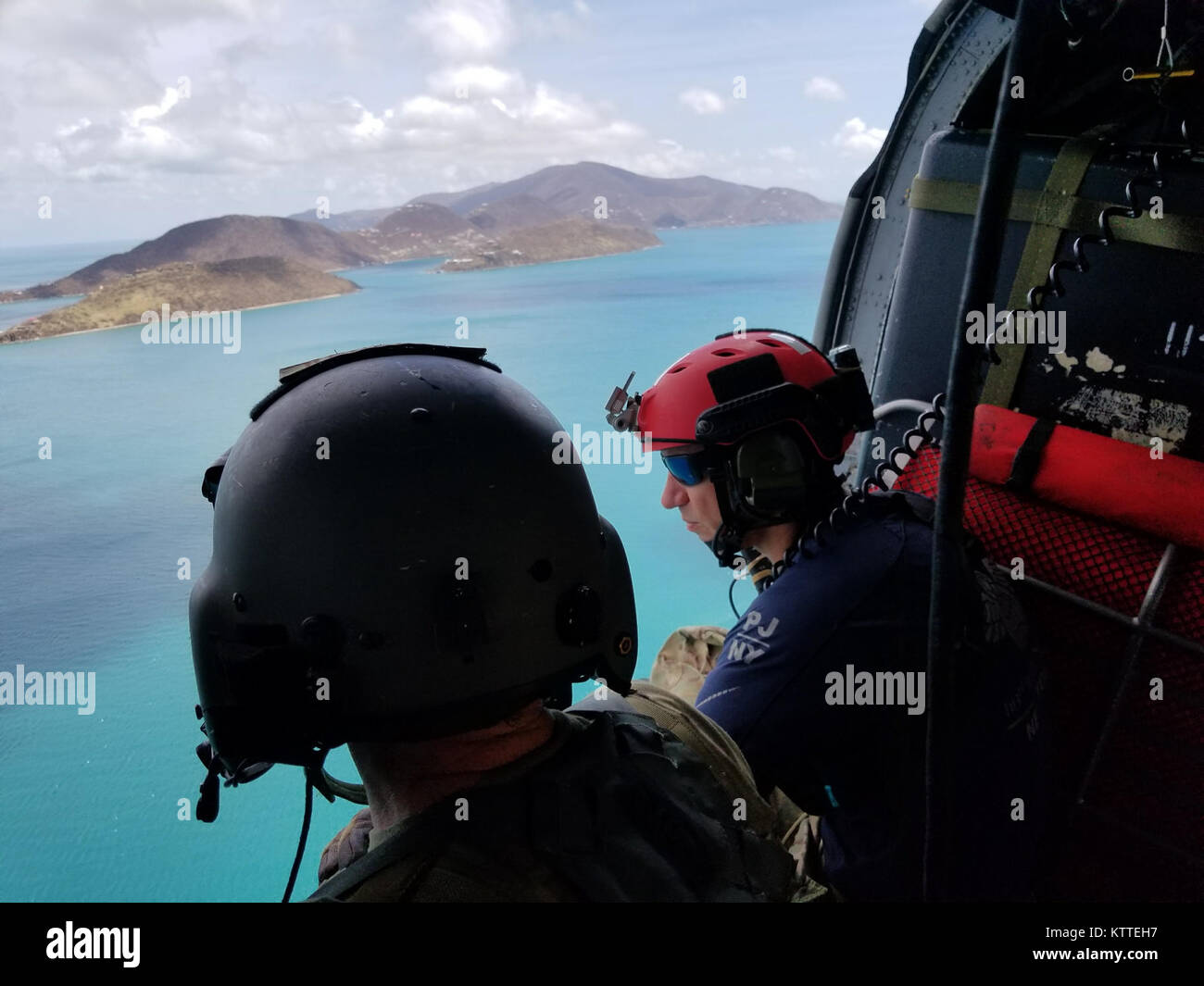 L'enquête sur la destruction de l'équipage de l'hélicoptère au-dessus des îles Vierges américaines. Aviateurs de la New York Air National Guard's 106th Rescue Wing voler plus de Saint-Thomas et Saint-John dans un HH-60 Pave Hawk helicopter le 10 septembre, 2017. Ils cherchent des personnes qui ont besoin d'une aide indispensable à la suite de l'ouragan l'Irma. Banque D'Images