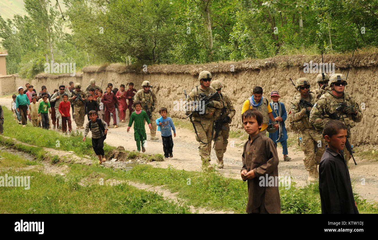 Des soldats de la 37e Brigade d'infanterie de l'équipe de combat et les villageois de Khwahan, province de Badakhshan, Afghanistan, marcher le long d'un chemin de terre vers le centre du village, le 3 juin 2012. La 5e équipe d'aide à la sécurité de la zone de travail de mentor à un programme d'action civique pour les femmes afghanes dans le village. 37e (IBCT photo par le Sgt. Kimberly Agneau) (Sortie) Banque D'Images