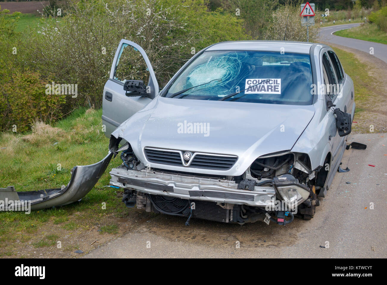 Dépouillé et vandalisée voiture abandonnée dans un chemin de campagne avec conseil sait autocollant à Surrey, Royaume-Uni de pare-brise Banque D'Images