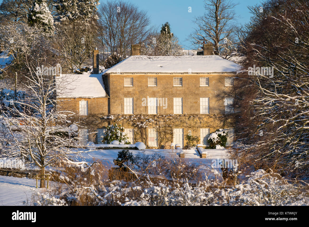 Kingham Hill Manor House dans la neige au lever du soleil en décembre. Kingham Hill, Cotswolds, Gloucestershire, Angleterre. Banque D'Images