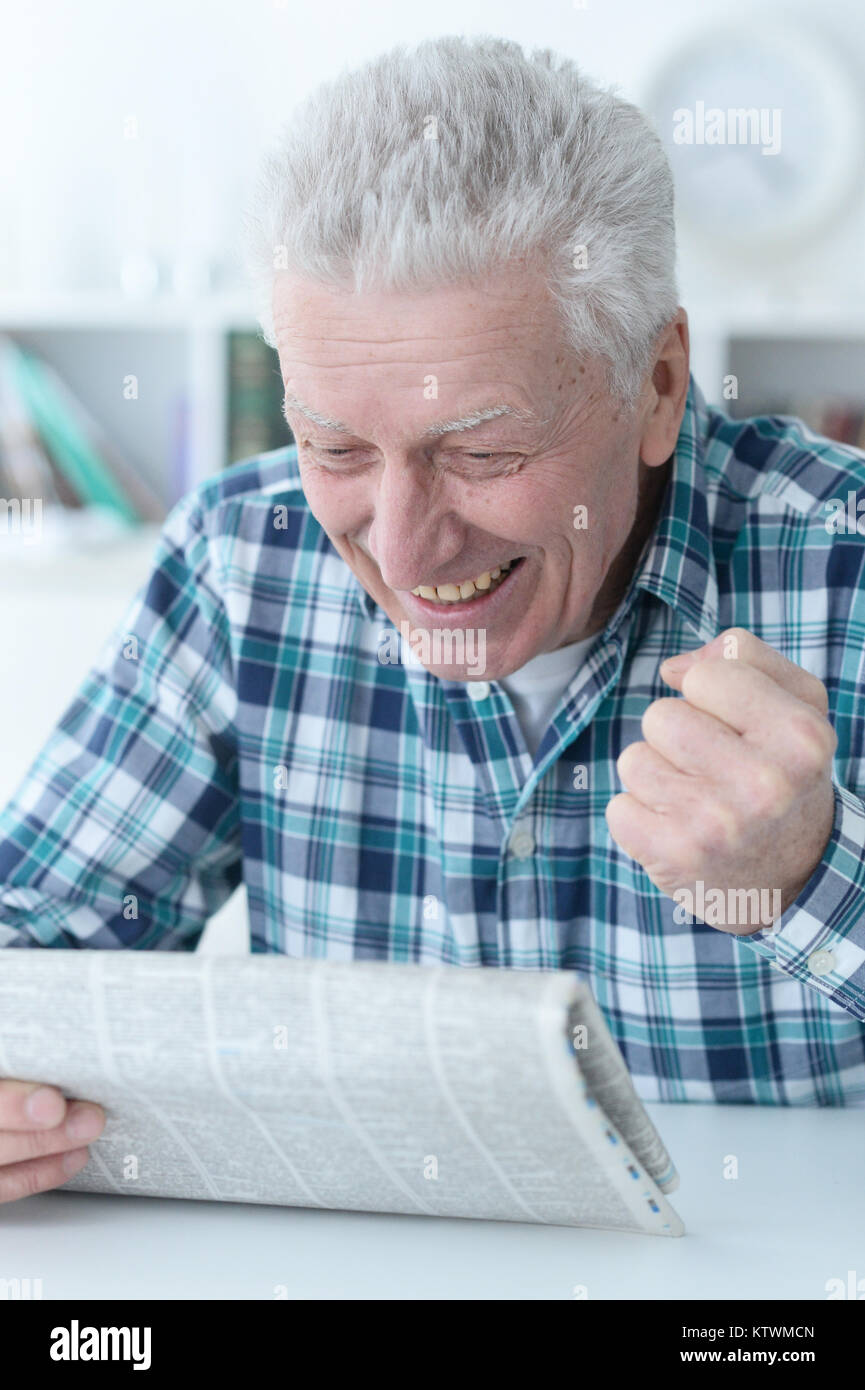 Senior man reading newspaper Banque D'Images