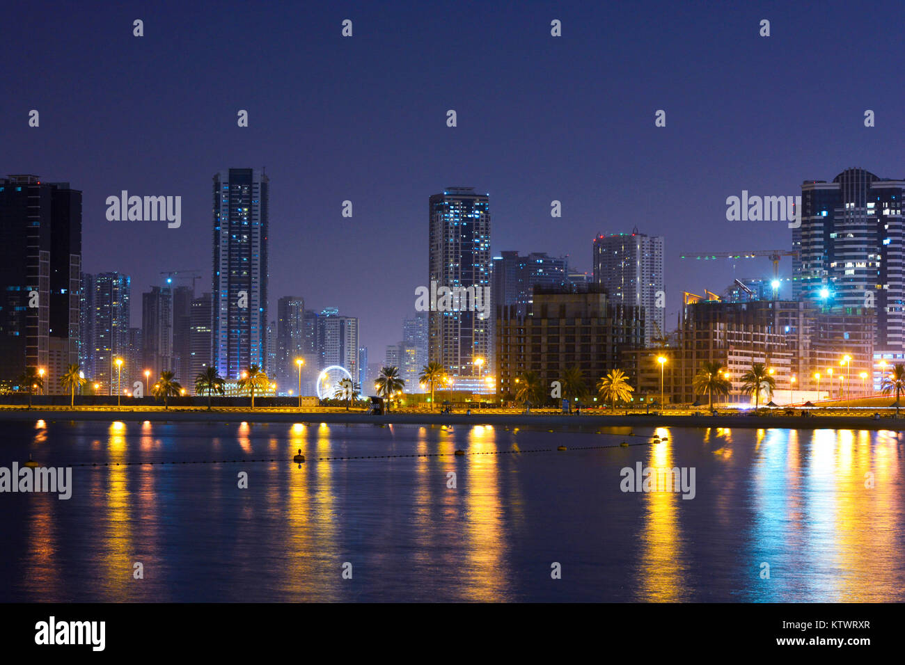 Dubaï, Émirats arabes unis. Une plage Vue de côté avec plusieurs couleurs de la réflexion des bâtiments et fond de ciel bleu. Banque D'Images