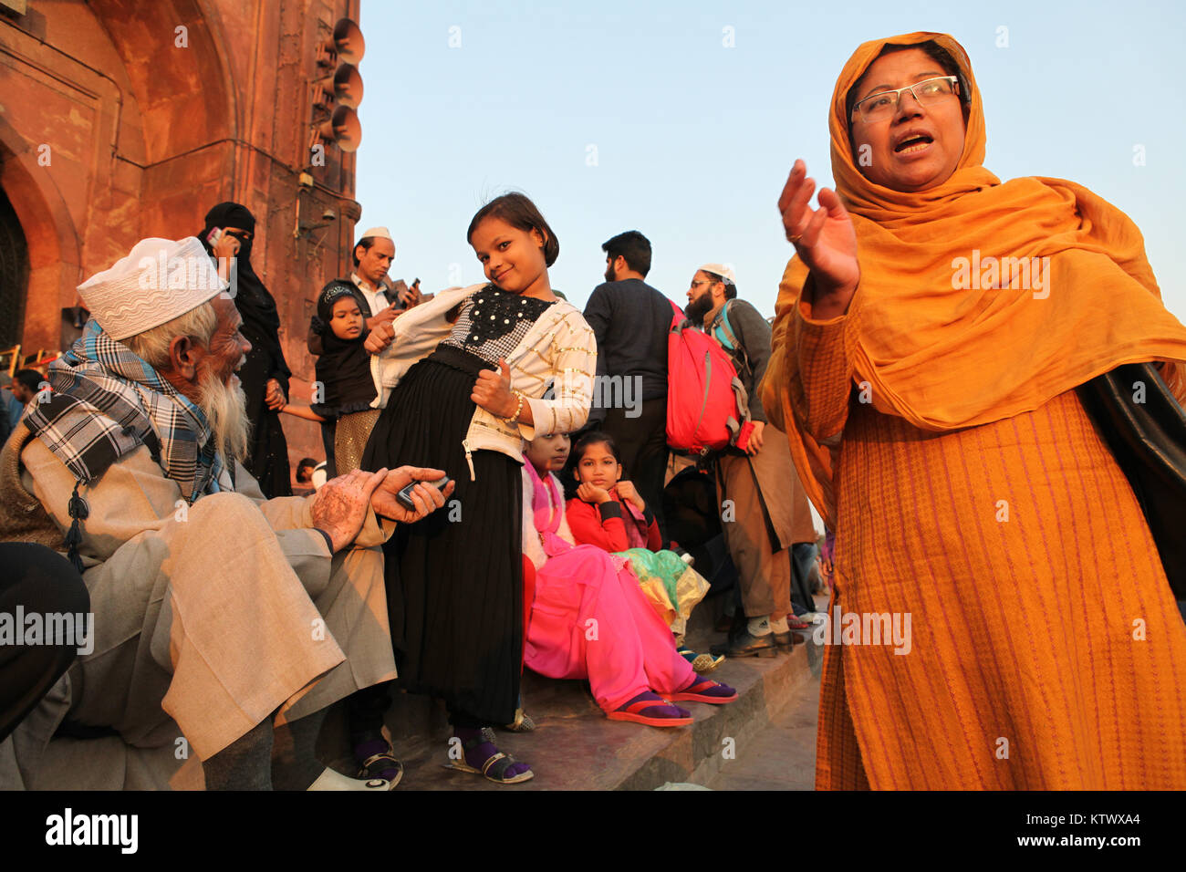 Les hommes et les femmes musulmanes sur les marches devant l'entrée de la Jama Masjid de New Delhi, Inde Banque D'Images
