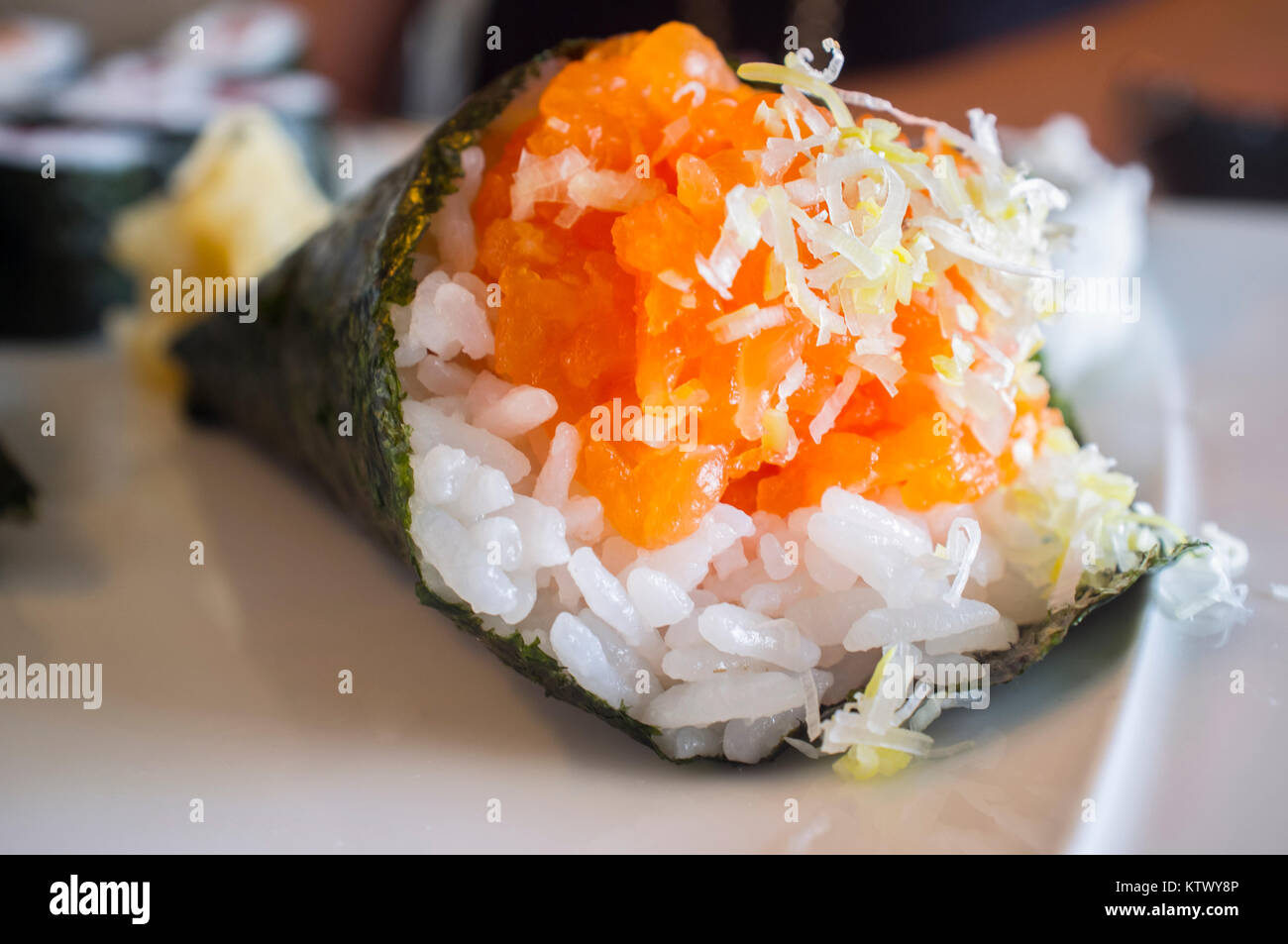 Temaki sushi saumon en forme de cône sur plaque blanche. Macro shot Banque D'Images