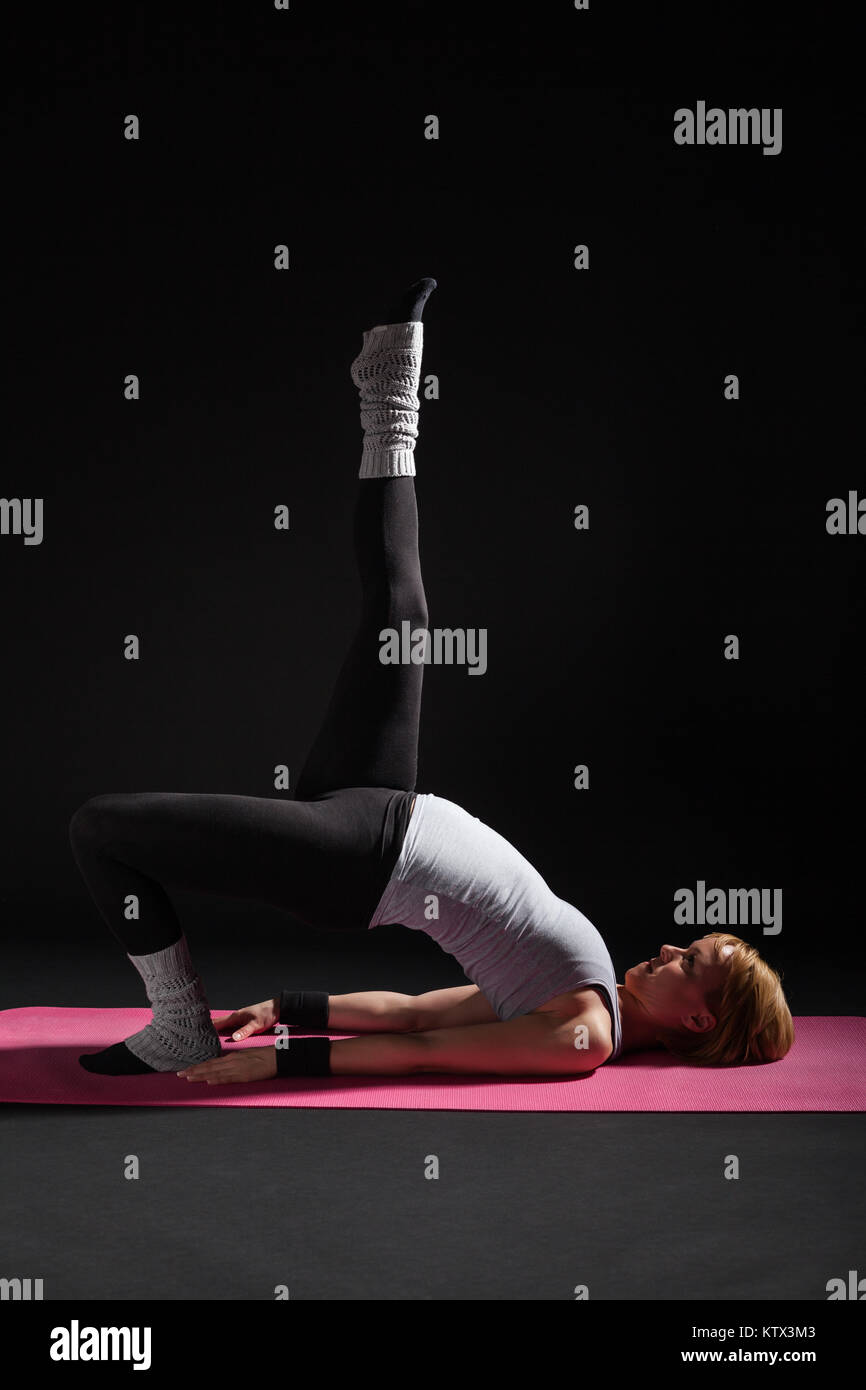 Young woman practicing yoga, Setuasana / poser demi-pont Banque D'Images