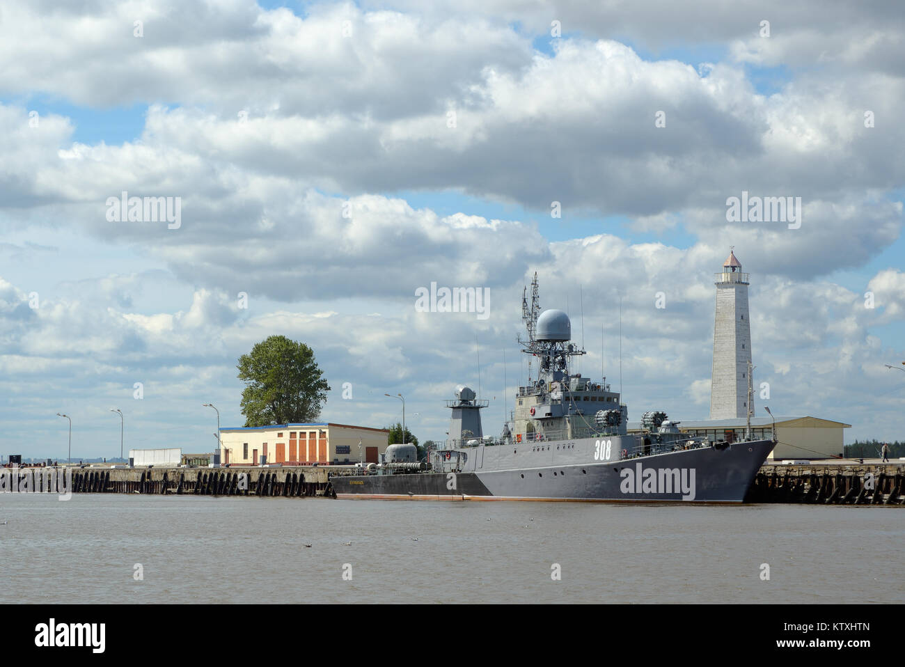 Kronstadt, Russie - le 14 juillet 2016 : Gris navire de guerre moderne à l'amarrage avec un phare en bois Banque D'Images