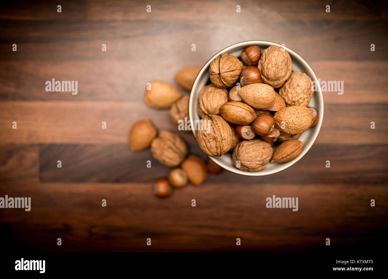 Un bol de fruits entiers mixtes en bonne santé dans leurs coquilles, y compris les noix, noisettes, amandes et noix de pécan en plongée des Banque D'Images