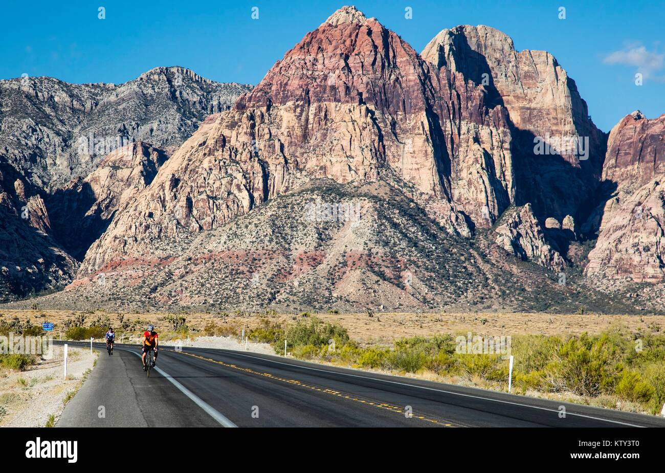 Les touristes à vélo sur la route près de la formations de roche de grès au Red Rock Canyon National Conservation Area, 29 septembre 2016 près de Las Vegas, Nevada. Banque D'Images