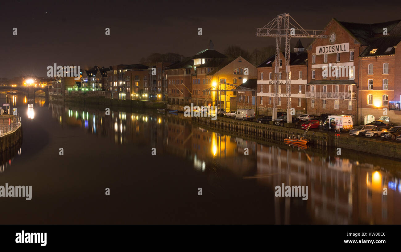 York, England, UK - 28 janvier 2017 : Entrepôts avec des grues et des immeubles d'appartements moderne line les quais de la rivière Ouse dans la nuit de New York. Banque D'Images