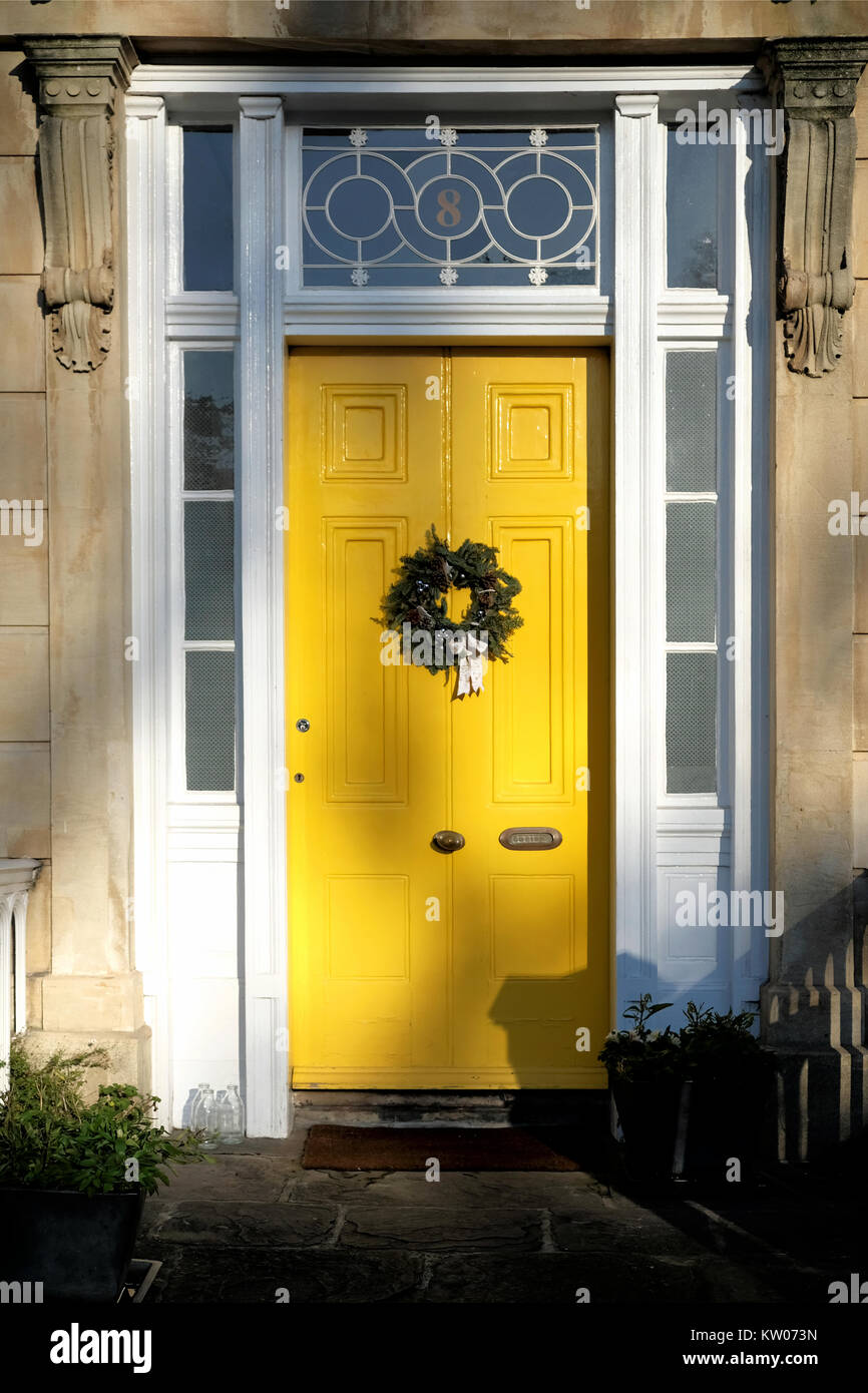 Une couronne de Noël fixée à un brillant yellw painted house porte. Son une ancienne maison victorienne à Clifton, Bristol sur un des hivers jour Banque D'Images