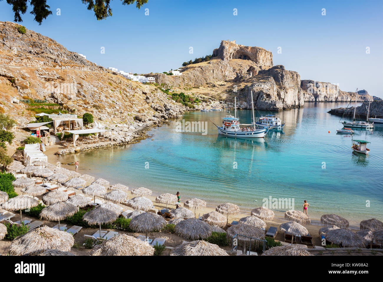 La baie de Saint Paul avec des bateaux, de l'Acropole de Lindos en arrière-plan (Rhodes, Grèce) Banque D'Images