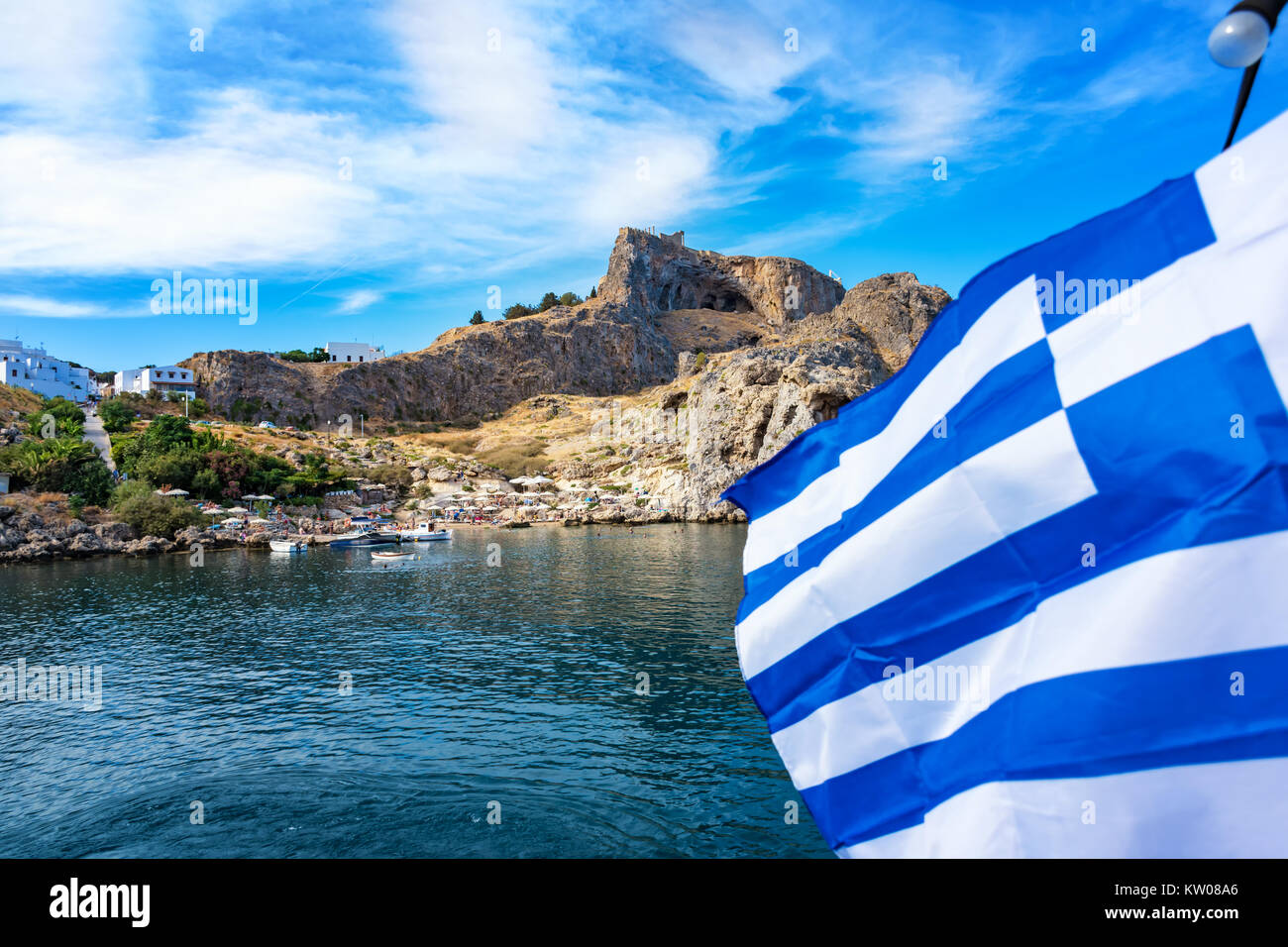 La baie de Saint Paul et drapeau grec, Lindos acropole en arrière-plan (Rhodes, Grèce) Banque D'Images