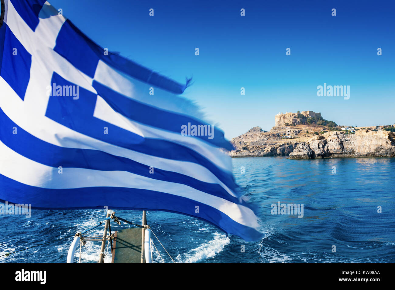 Drapeau grec et Acropole de Lindos en arrière-plan de pont de bateau (Rhodes, Grèce) Banque D'Images