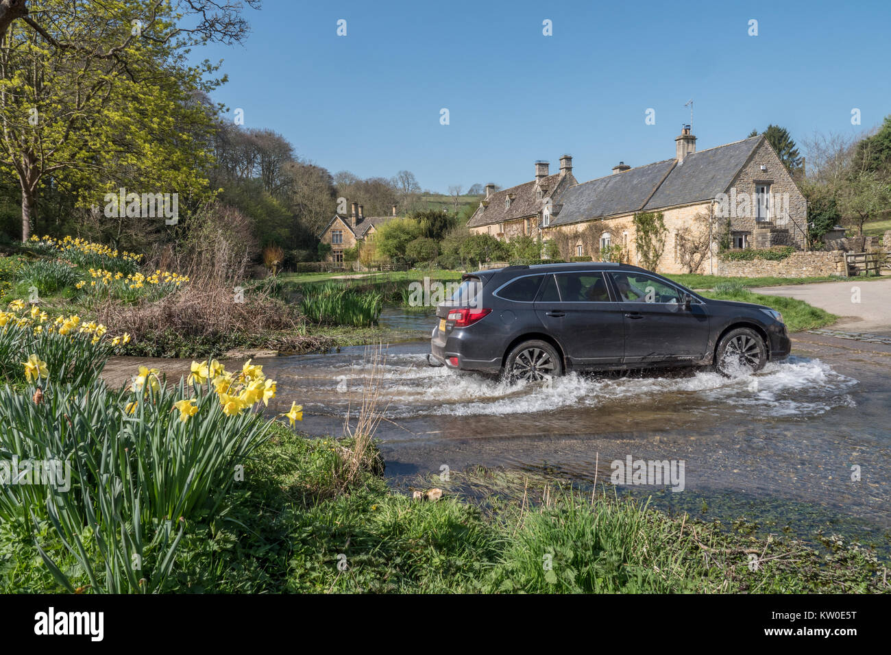 Une voiture conduit par un gué sur la rivière Eye dans le pittoresque village de Cotswold abattage supérieur, Gloucestershire, Angleterre, Royaume-Uni. Banque D'Images