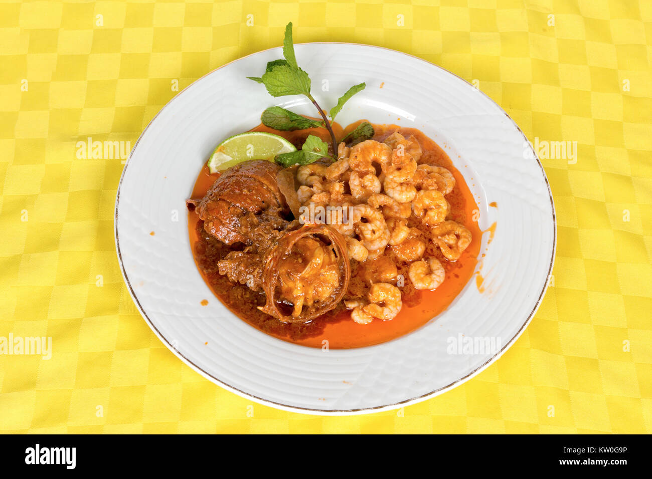 Queues de homard et crevettes mélangées à la sauce tomate dans un plat blanc Banque D'Images