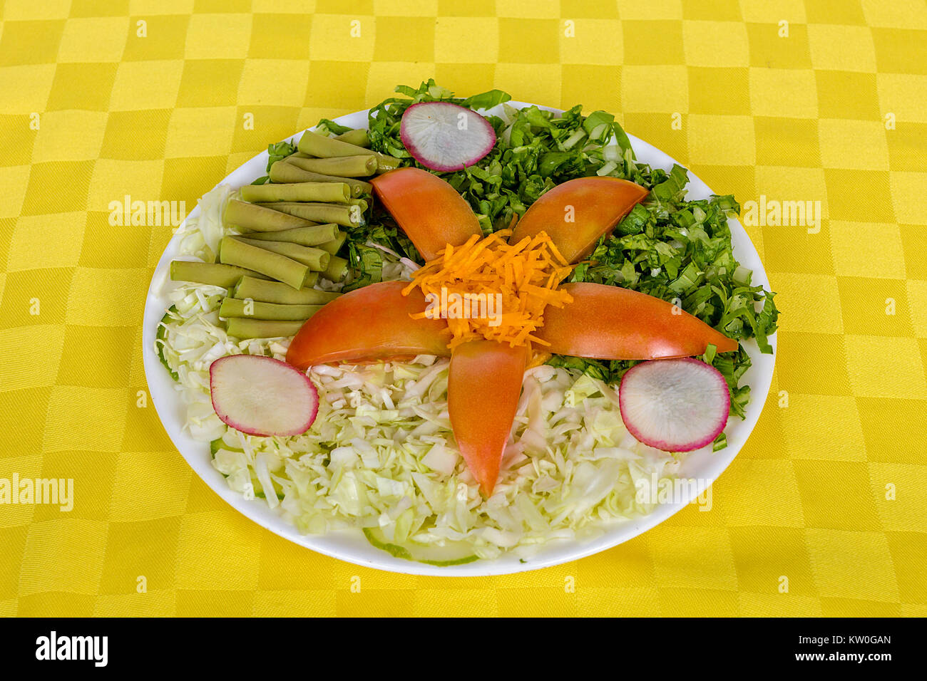 Un plat blanc servi avec tomate, chou, haricots, radis, la laitue et la carotte Banque D'Images