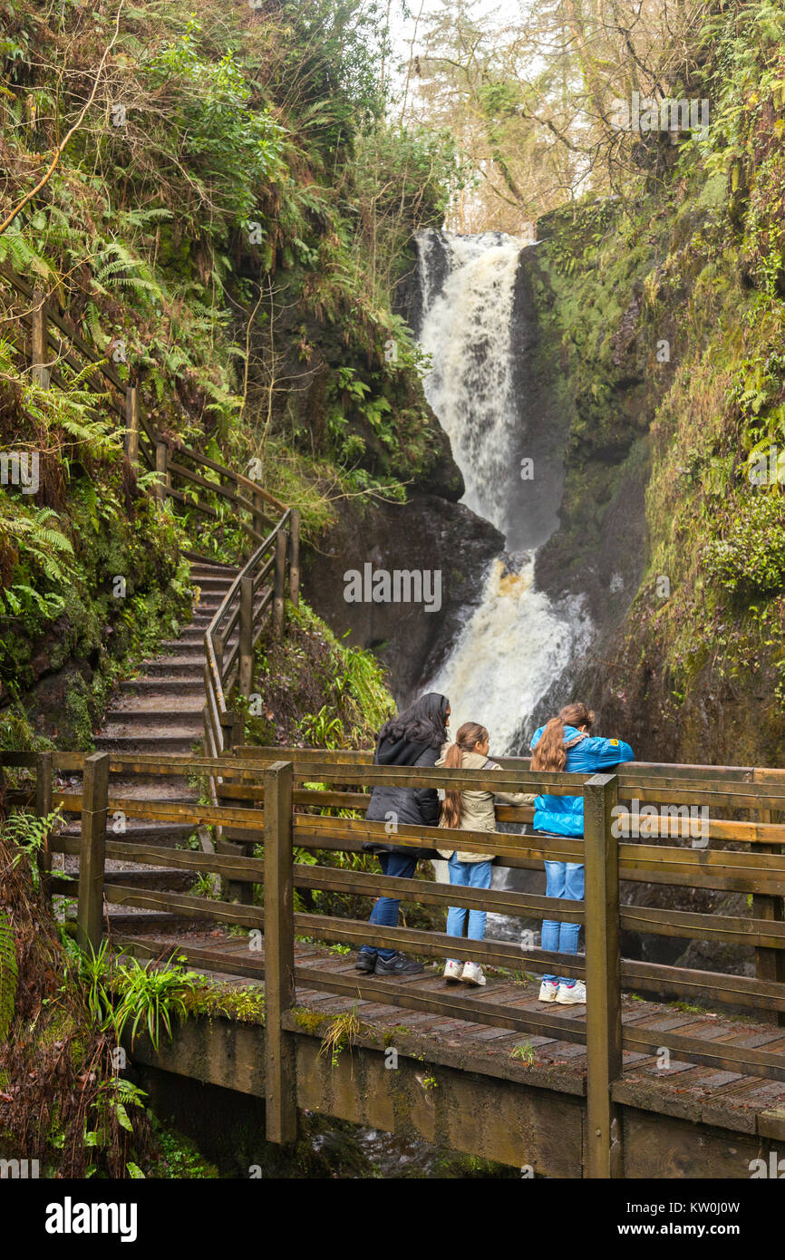 Ess-na-larach cascade dans le parc forestier de Glenariff avec une famille à la recherche sous un pont en bois Banque D'Images