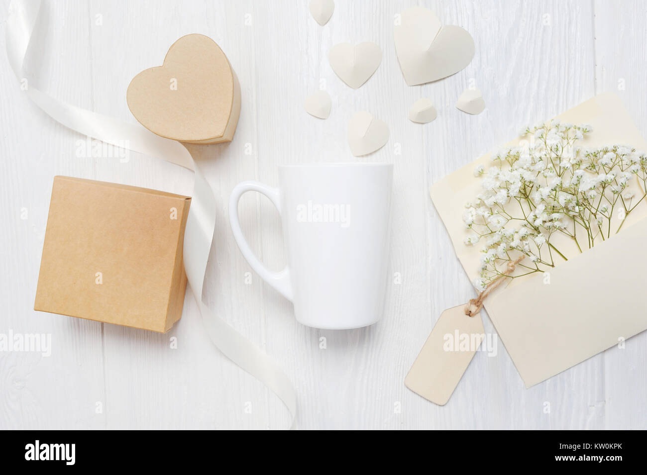 Immersive pour la Saint-Valentin carte de souhaits lettre dans une enveloppe et mug avec boîte coeur gif, flatlay on a white background, avec place pour votre Banque D'Images