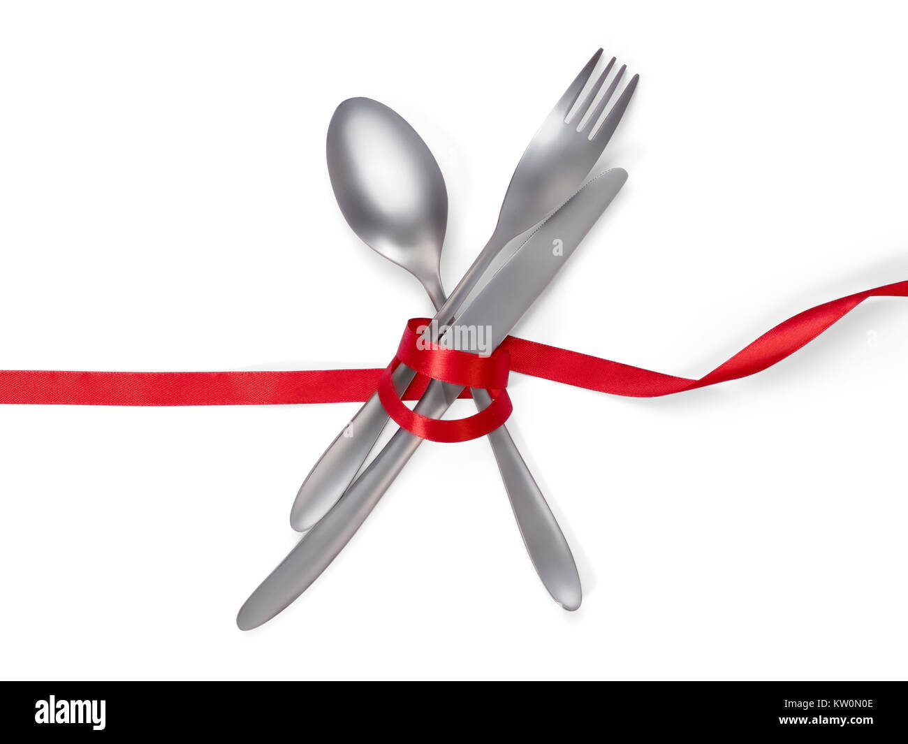 Cuillère, fourchette et couteau attaché avec un ruban rouge isolé sur blanc, chemin de détourage inclus. Alimentation, restaurant et de table thème Banque D'Images