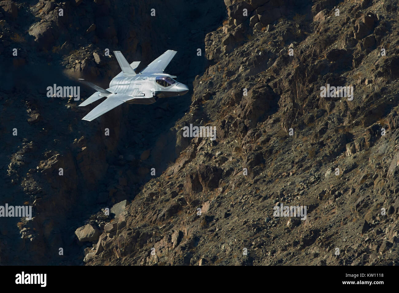 Un monde futuriste et Lockheed Martin F-35A Lightning II Joint Strike Fighter (Stealth Fighter), volant à faible niveau par l'intermédiaire d'un Canyon désert en Californie, USA. Banque D'Images