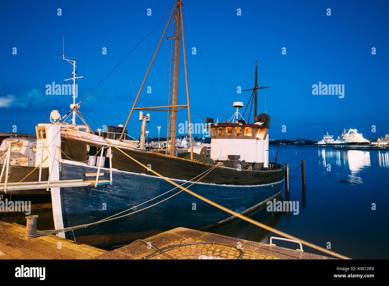 Helsinki, Finlande. Avis de Marine, bateau de pêche bateau au quai en Soir Nuit Illuminations. Banque D'Images