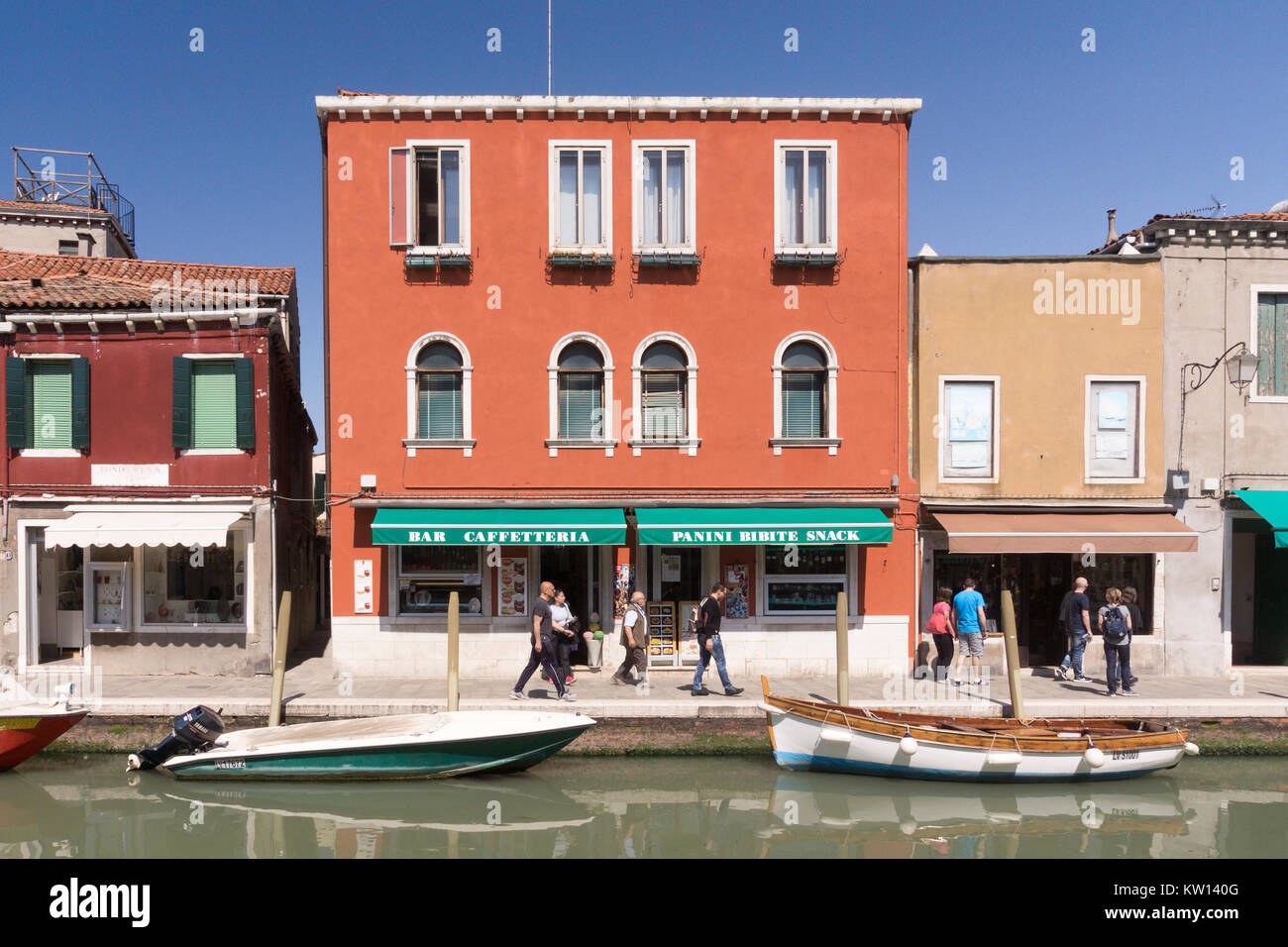 Les touristes en passant devant un bar aux couleurs vives et d'un café sur l'île de Murano, Venise Banque D'Images
