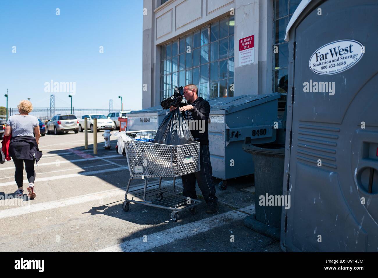 Dans le bassin de la Chine près de San Francisco, un sans-abri d'une benne à ordures de charges dans un panier, 2016. Banque D'Images