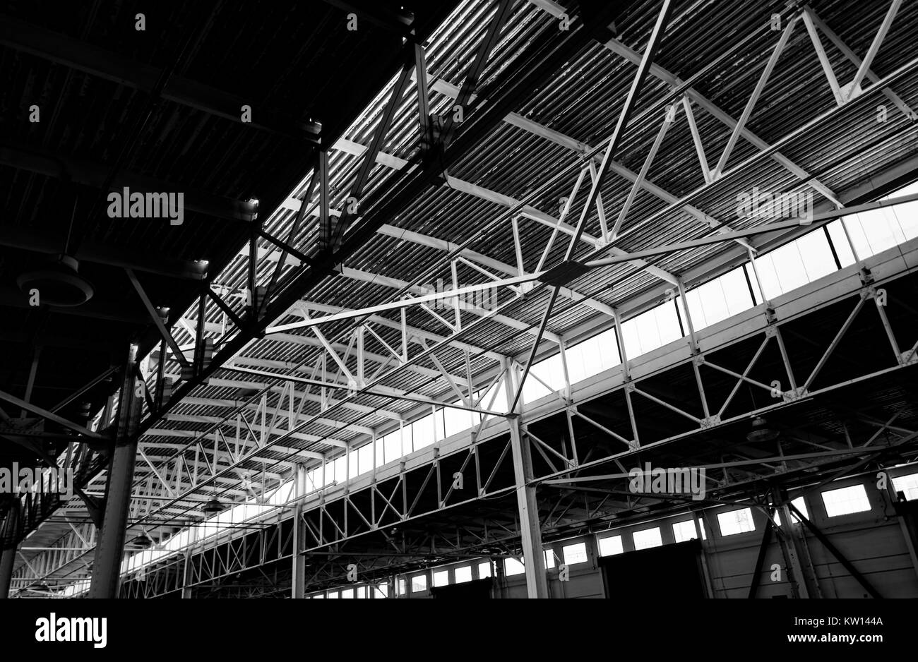 Image en noir et blanc de la complexité des accolades métalliques soutenant le toit de Pier 48, un hangar, un ancien hangar de stockage au Port de San Francisco, maintenant utilisé comme un terrain de stationnement, San Francisco, Californie, 2016. Banque D'Images