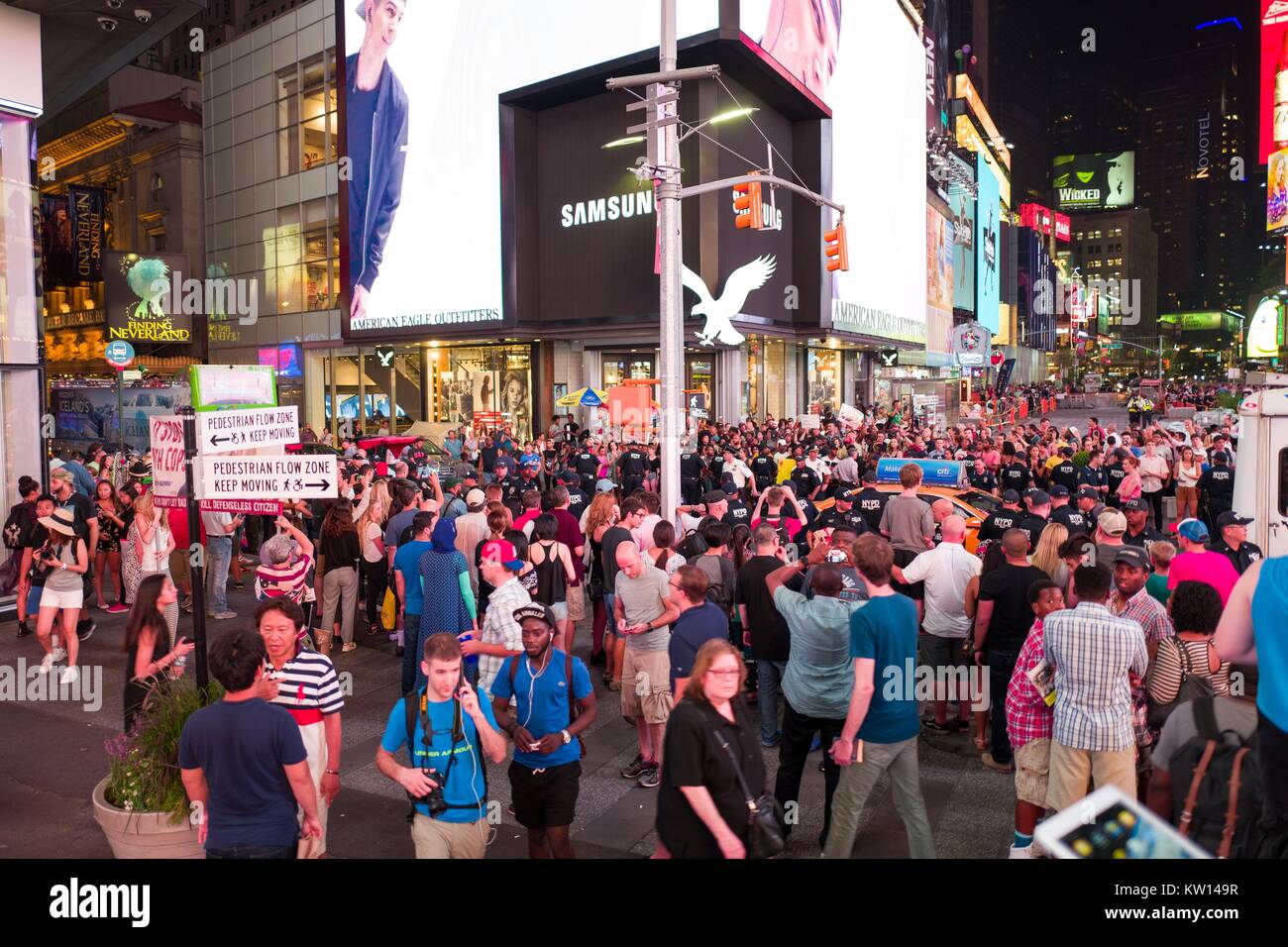 Au cours d'une vie noir Question manifestation à New York Times Square à la suite des coups de décès de Alton Sterling et Philando Castille, militants de bloquer le trafic et affrontez une ligne de policiers de New York (NYPD) La police anti-émeute en touristes regard sur 2016. Banque D'Images