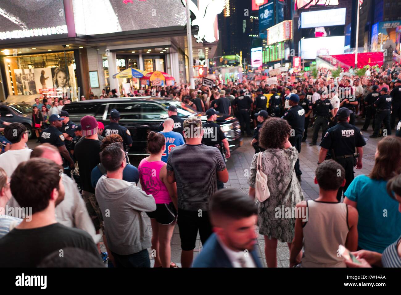 Au cours d'une vie noir Question manifestation à New York Times Square à la suite des coups de décès de Alton Sterling et Philando Castille, un SUV noir passe vite dans une intersection en tant que militants de bloquer le trafic et affrontez une ligne de policiers de New York (NYPD) La police anti-émeute et les touristes regarder sur 2016. Banque D'Images