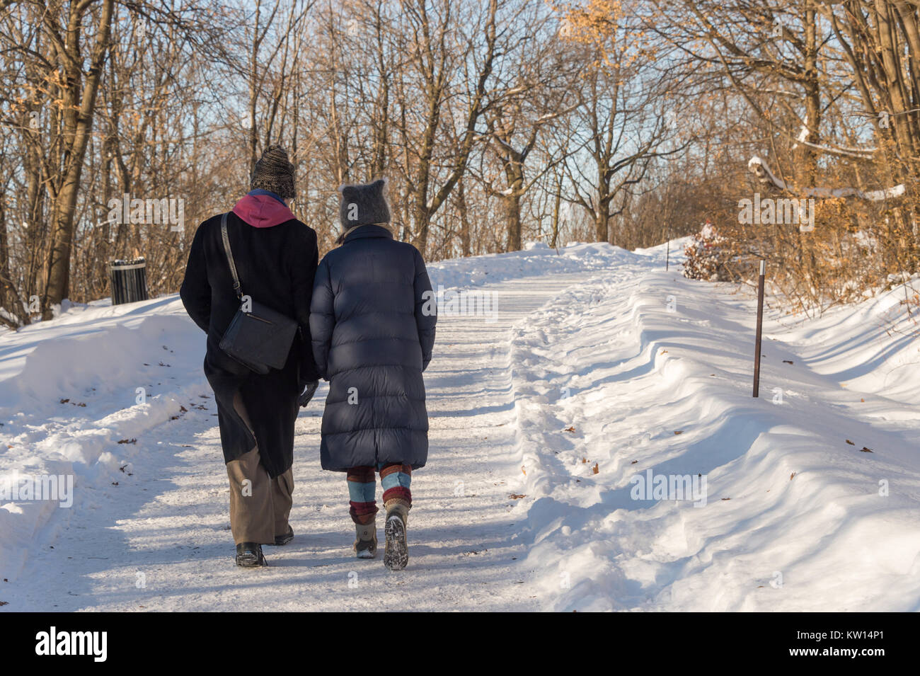 Montréal, CA - 26 décembre 2017 : couple en train de marcher sur un sentier enneigé à Montréal sur le mont Royal Park (parc du Mont-Royal) Banque D'Images