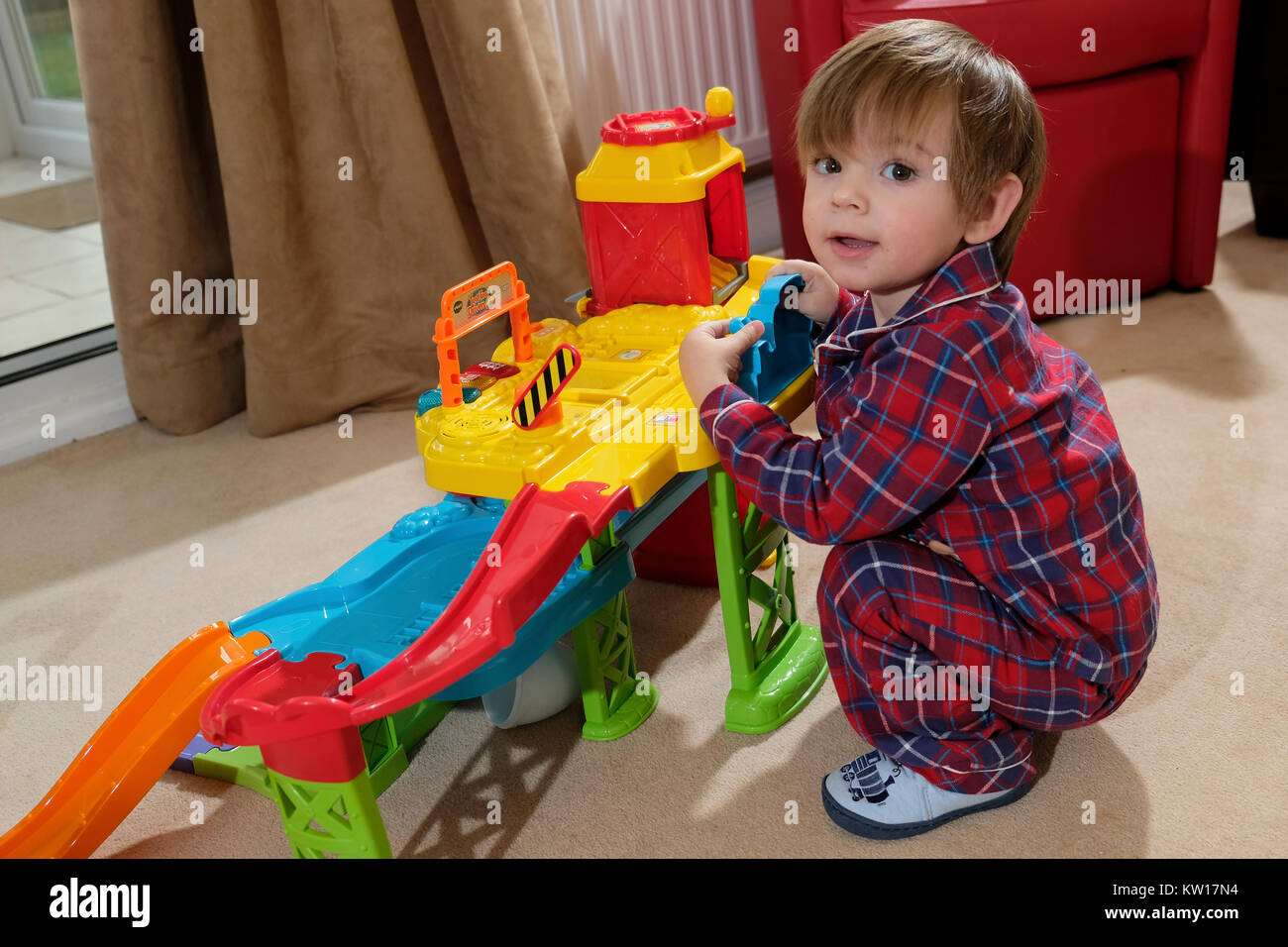 Tout-petits de 18 mois en pyjama enfant jouet jouer avec garage Photo Stock  - Alamy